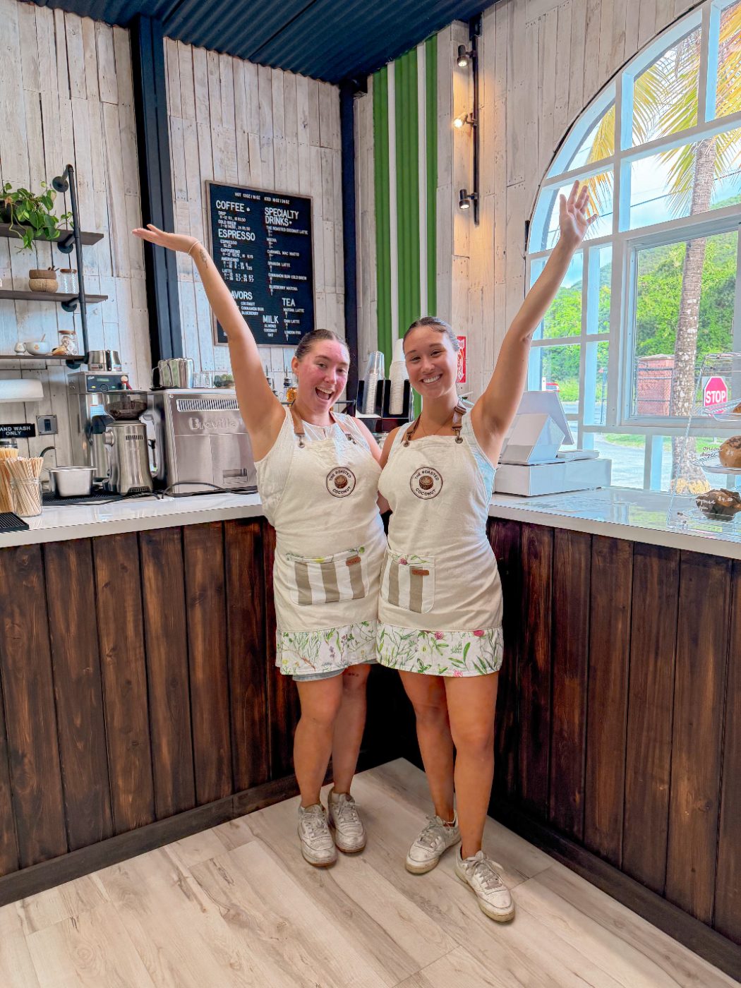 The two sisters who own The Roasted Coconut waving from behind the counter